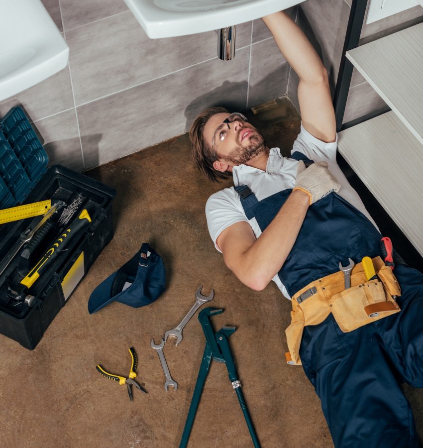 high-angle-view-of-young-male-plumber-fixing-sink-in-bathroom.jpg